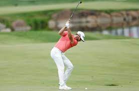 Golf player swinging a golf club at a golf ball to break 100 